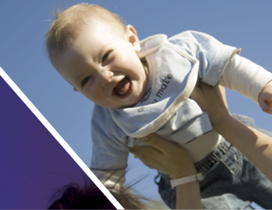 Baby being held up against a blue sky