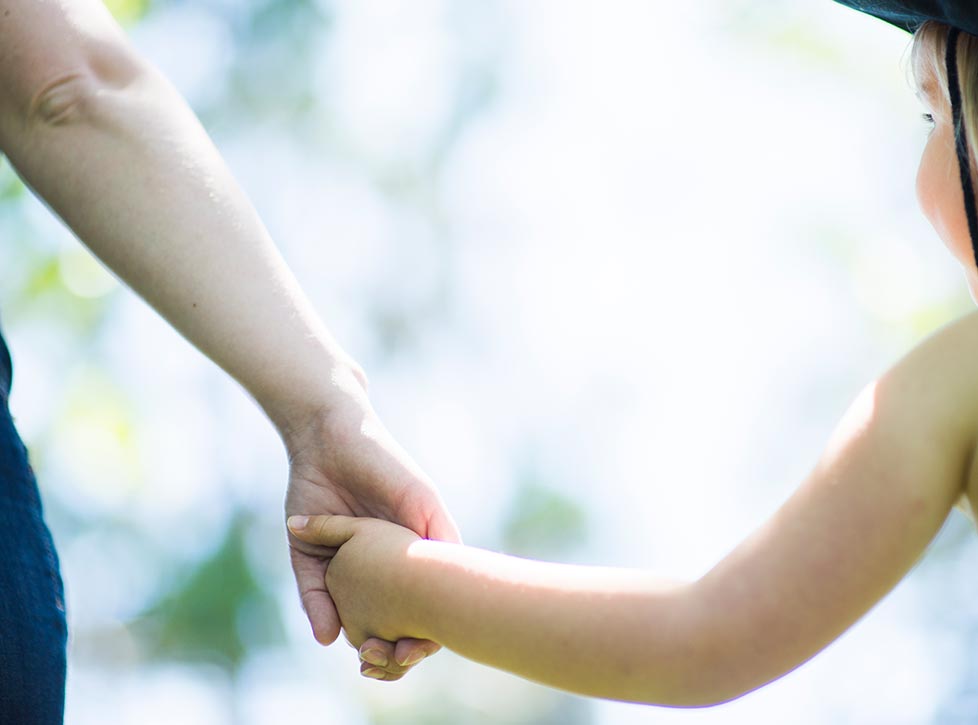 Young girl holding hands with adult